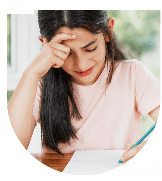 a girl in a pink shirt concentrates on writing