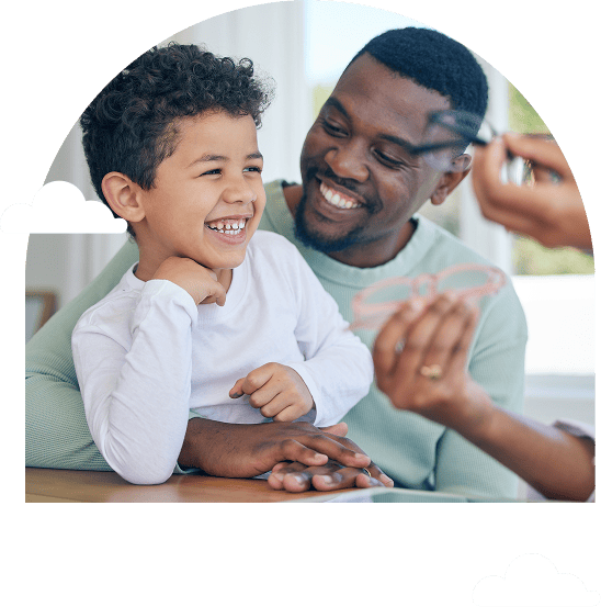 father and son smiling together as a hand offers glasses
